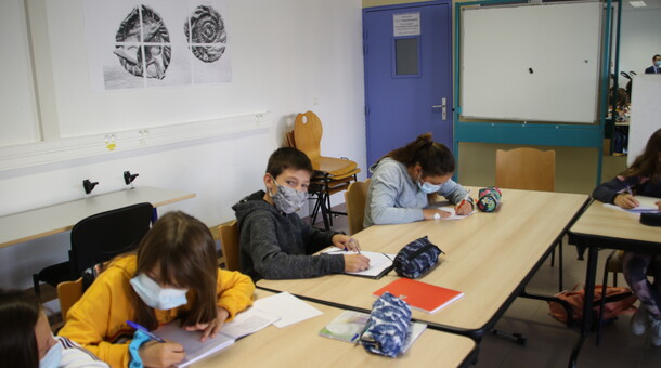 Photo de trois élèves en train d'écrire