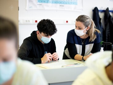 Une enseignante aux côtés d'un élève